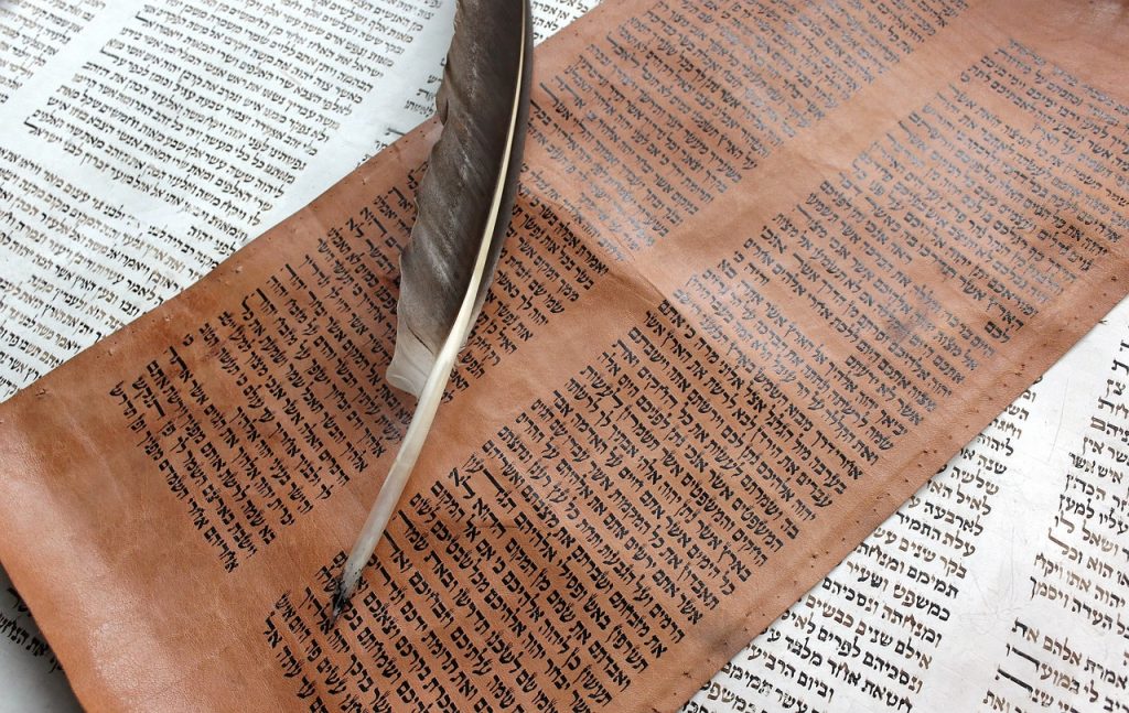 Bibel in hebräischer Schrift mit Federkiel.